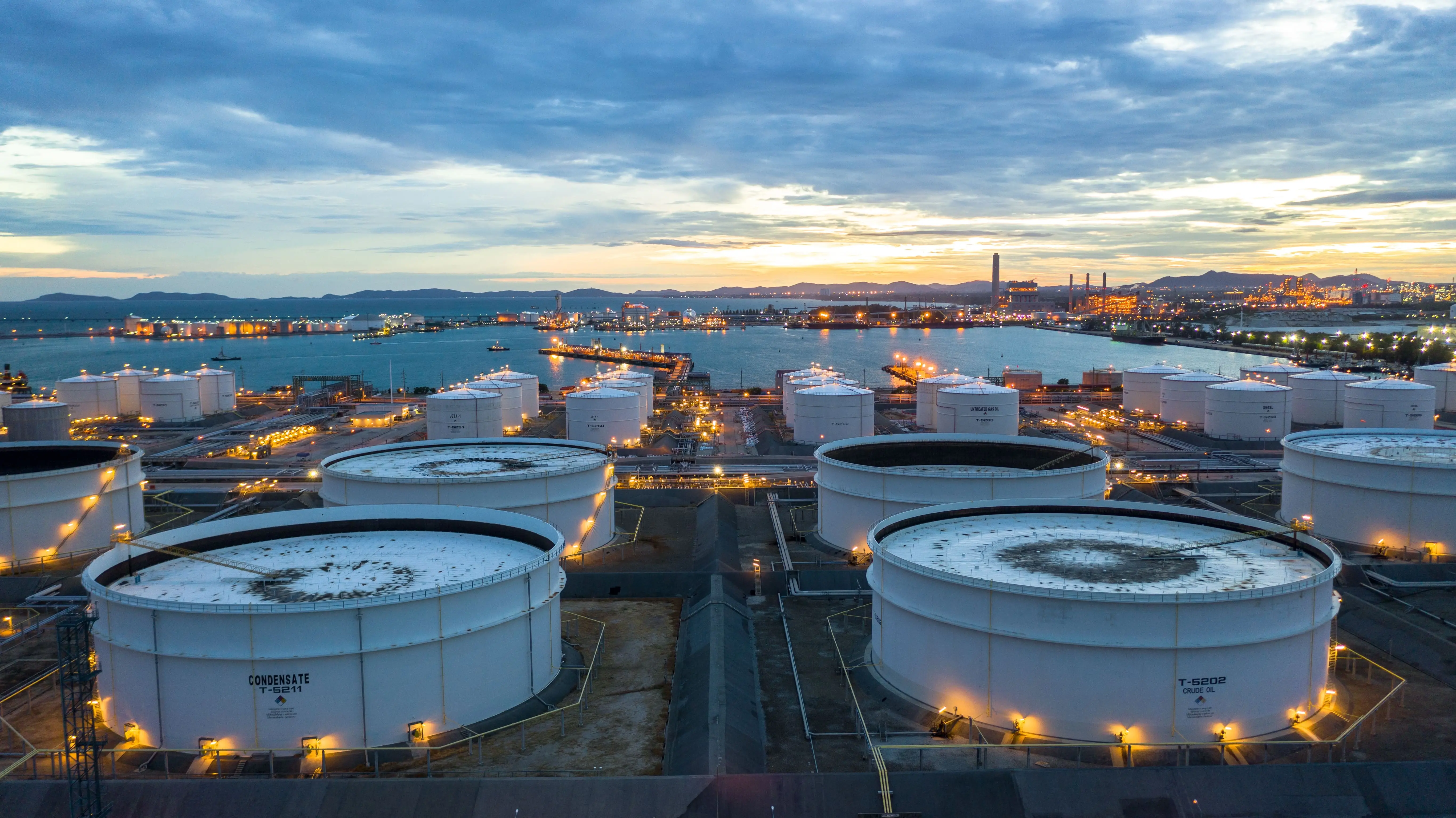 Industrial blue storage tanks and silos under clear sky, representing refined petroleum products processing and storage
